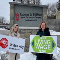 United way and Usborne Hibbert representatives standing in-front of Usborne and Hibbert sign